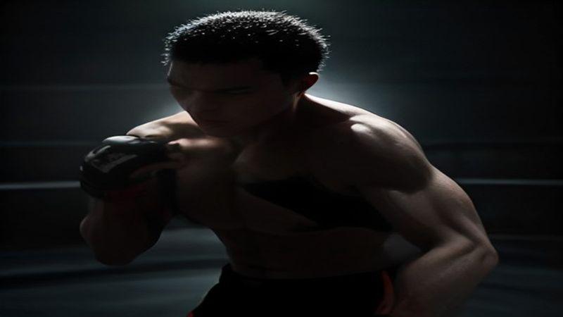 นักสู้ MMA พันมือในมุมเวทีแสงสปอตไลต์